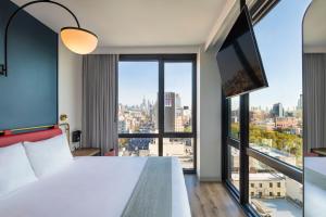 纽约Moxy NYC Lower East Side的酒店客房设有一张床和一个大窗户