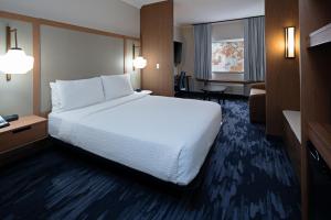 西塔科Fairfield by Marriott Inn & Suites Seattle Sea-Tac Airport的酒店客房设有一张大床和一张书桌。