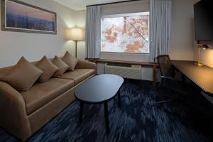 西塔科Fairfield by Marriott Inn & Suites Seattle Sea-Tac Airport的带沙发、桌子和窗户的客厅