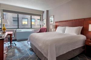 纽约纽约曼哈顿/第五大道万怡酒店的酒店客房设有一张大床和浴缸。