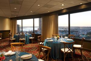 圣地亚哥圣地亚哥市中心小意大利福朋喜来登酒店 的餐厅设有桌椅和大窗户。