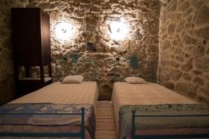 瓦莱迪坎布拉Casas dos Avos的石墙客房的两张床