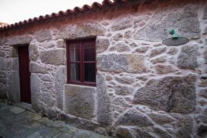瓦莱迪坎布拉Casas dos Avos的一座石头建筑,设有窗户和灯
