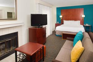 安大略安大略机场原住客栈 的酒店客房配有床、沙发和电视。