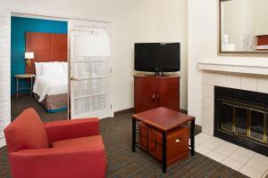 安大略安大略机场原住客栈 的酒店客房带一张床、一台电视和一把椅子