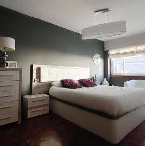 拉科鲁尼亚APARTAMENTO TORRE DE HÉRCULES A CORUÑA con GARAJE的卧室设有一张白色大床和一扇窗户。