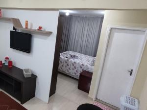 波苏斯-迪卡尔达斯Estúdio Mobiliado em Poços的客房设有带一张床和镜子的卧室