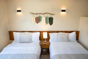 卡门城Casa Viento Hotel的两张睡床彼此相邻,位于一个房间里