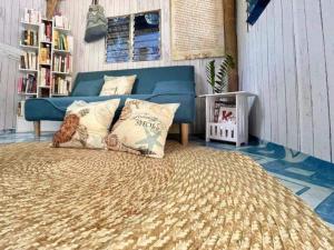 LingayenBeachfront Glamping with Mini Pool Exclusive Property的一间卧室配有蓝色的沙发和带枕头的床