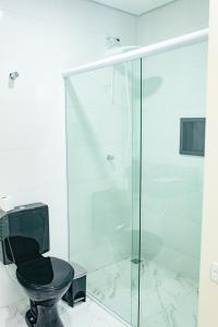 圣保罗Hotel Tenda Obsession的浴室内带黑色卫生间的玻璃淋浴间