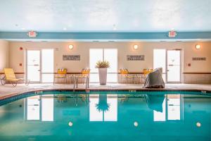 绿湾格林湾西南万豪费尔菲尔德酒店的一座配有桌椅的酒店游泳池