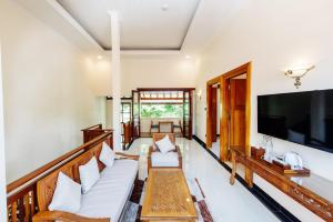 TimuranTirtodipuran Hotel Yogyakarta的客厅配有白色家具和平面电视