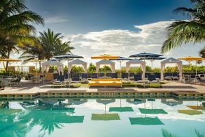 帕诺滩劳德代尔堡万豪帕诺海滩度假酒店&Spa的一个带遮阳伞和桌椅的游泳池