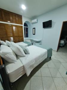 圣玛尔塔Casa Blanca del Mar的一间卧室设有四张床和一台平面电视。
