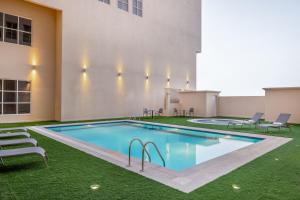 达曼Residence Inn by Marriott Dammam的建筑物一侧的游泳池