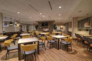 加特林堡Fairfield Inn & Suites by Marriott Gatlinburg Downtown的一间带桌椅和壁炉的餐厅