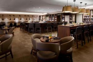 温莎Marriott Hartford/Windsor Airport的一间带桌椅的餐厅和一间酒吧