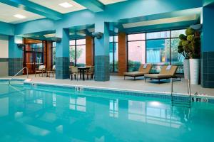温莎Marriott Hartford/Windsor Airport的蓝色墙壁的酒店客房中的游泳池