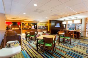 贝城Fairfield Inn & Suites by Marriott Bay City, Texas的一间带桌椅的餐厅和一间酒吧