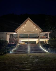 马比尼Amor Laut的一座晚上有楼梯和灯光的建筑