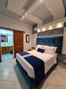 圣玛尔塔Casa Blanca del Mar的一间卧室配有一张大床和蓝色床头板
