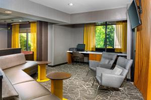 阿什维尔阿什维尔春季山丘套房酒店的酒店客房设有带椅子和书桌的等候区。