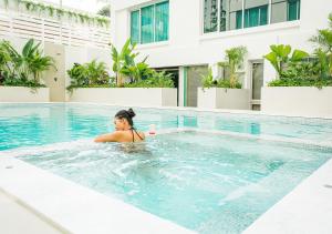 曼谷素坤逸10中心点酒店的妇女在酒店游泳池里