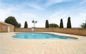 波尔蒂拉盖Awesome Home In Portiragnes With Outdoor Swimming Pool的一个带围栏和树木的庭院内的游泳池