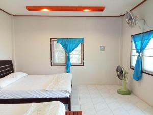 哈林海滩帕岸岛海洋度假村的一间卧室设有两张床,窗户配有蓝色窗帘