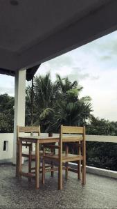 PlambiTiara Homestay的两座木凳,坐在棕榈树建筑下