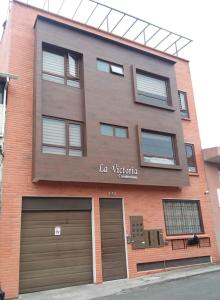 昆卡Departamento 2B en Condominio La Victoria的一座大型砖砌建筑,设有两个车库和两个车库门