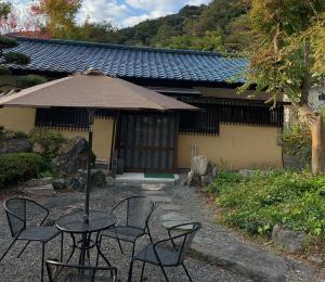 富士宫市HOSHIYAMA A extra for pets - Vacation STAY 07884v的大楼前的桌椅和遮阳伞