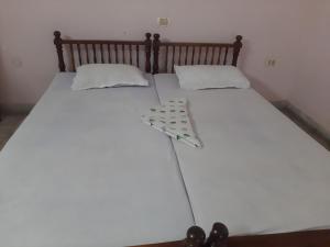 可瓦兰Hotel Peacock的一张白色的床,上面有两个枕头