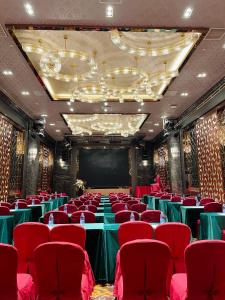 深圳深圳水都假日酒店（火车北站)的一间会议室,配有红色椅子和屏幕