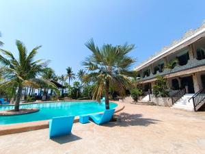 莫阿尔博阿The Wild Orchid Resort - Moalboal的一座大楼前的游泳池,配有两把蓝色椅子