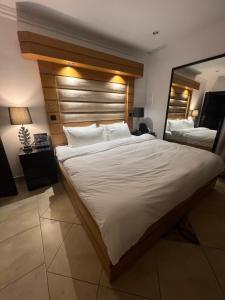 科威特Bneid Al Gar Penthouse Entire Apartment 3 Bedroom Family Only的一间卧室配有一张大床和木制床头板