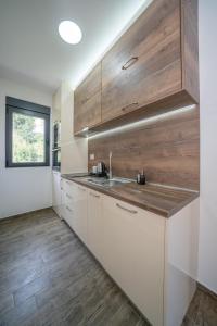科托尔Marea DeLuxe Apartments的厨房配有白色橱柜和木墙