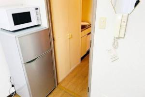 Sanukiマリオン屋島東906号的厨房配有冰箱上方的微波炉
