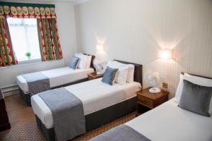梅德斯通Hamlet Hotels Maidstone的酒店客房设有两张床和窗户。