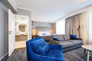 塔尔图Dorpat Hotel的带沙发和蓝椅的客厅