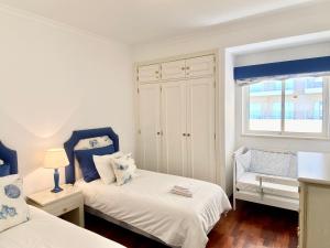 维拉摩拉Vilamoura Central 2 Bedroom Apartment的一间卧室设有两张床和窗户。