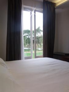 茹瓦尼左岸餐厅酒店的一间卧室设有一张大床和一个窗户。