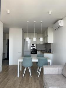 利沃夫VIP Apartmens Avalon的厨房以及带桌椅的起居室。