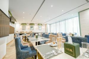 迪拜Azur Regency Hotel Apartments的一间配备有桌子和蓝色椅子的用餐室