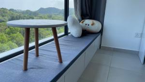 山打根Sandakan Homestay Apartment Forest Cabin 森林小屋 2R2B的坐在窗台上的桌子