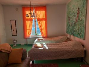 瓦尔考斯Nostalgista majoittumista Taiteilijatalo Taideniityn Auringossa tai Niityssä的一间卧室设有两张床、一张沙发和一个窗口