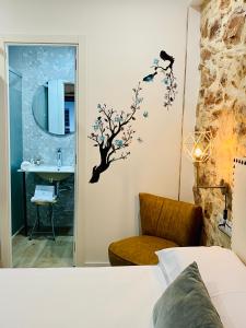 贝尼卡西姆Soléa House Hotel Boutique的一间卧室,浴室的墙上贴有树贴