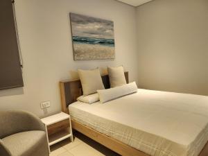 格兰贝伊Soleia 3 in Mauritius的一间卧室配有一张带椅子和绘画的床