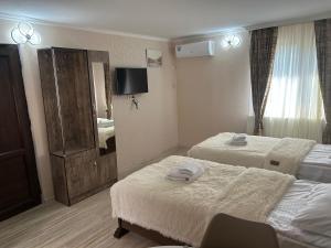 姆茨赫塔Oldtown Apartments的酒店客房设有两张床和电视。