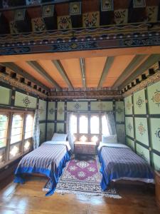 普纳卡Mendrelgang Homestay的配有两张床铺的绿色墙壁和窗户